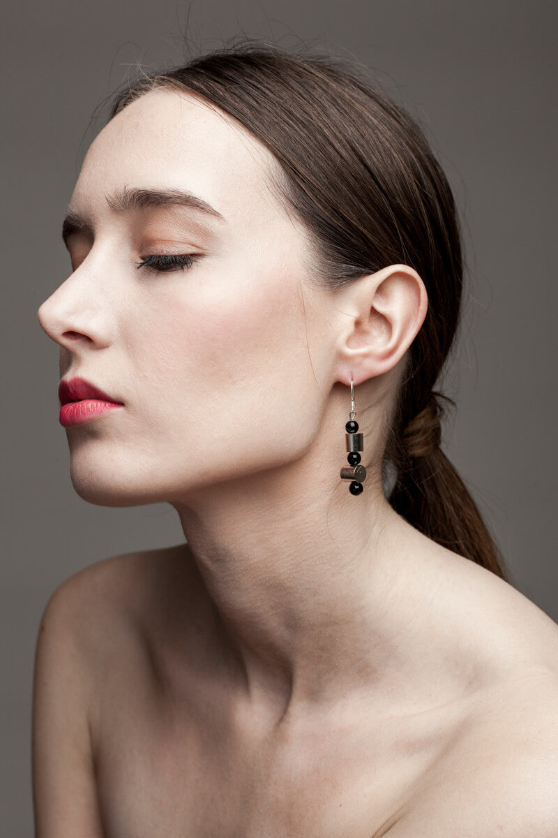 This mismatched earrings are made of hand cut and galvanized brass, onyx and sterling silver.